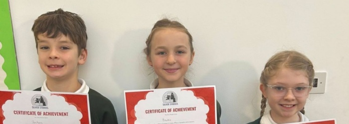 Children from Exwick Heights holding certificates